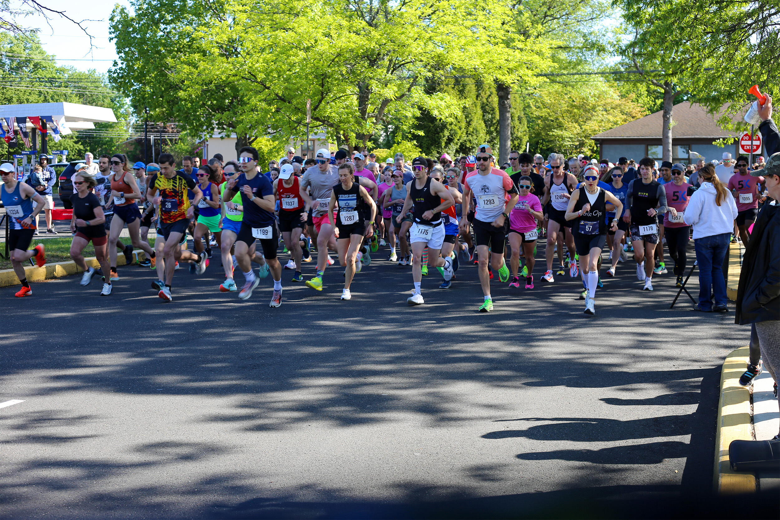 A large pack of runners surging forward at the mass start of the YMCA Bucks County Strong 5K